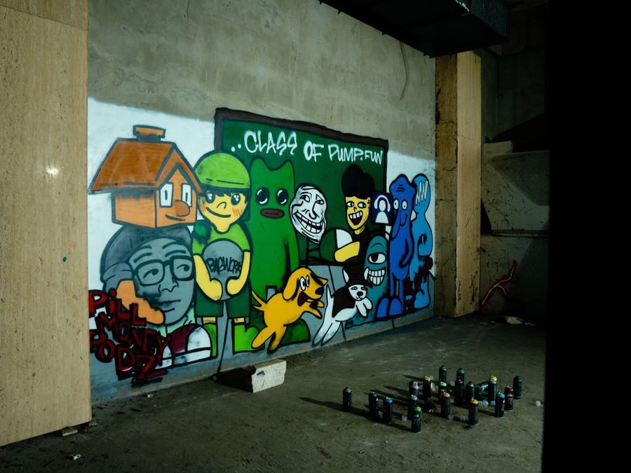 The Class of Pump.fun mural by Pill Money Podz, spray cans on the floor